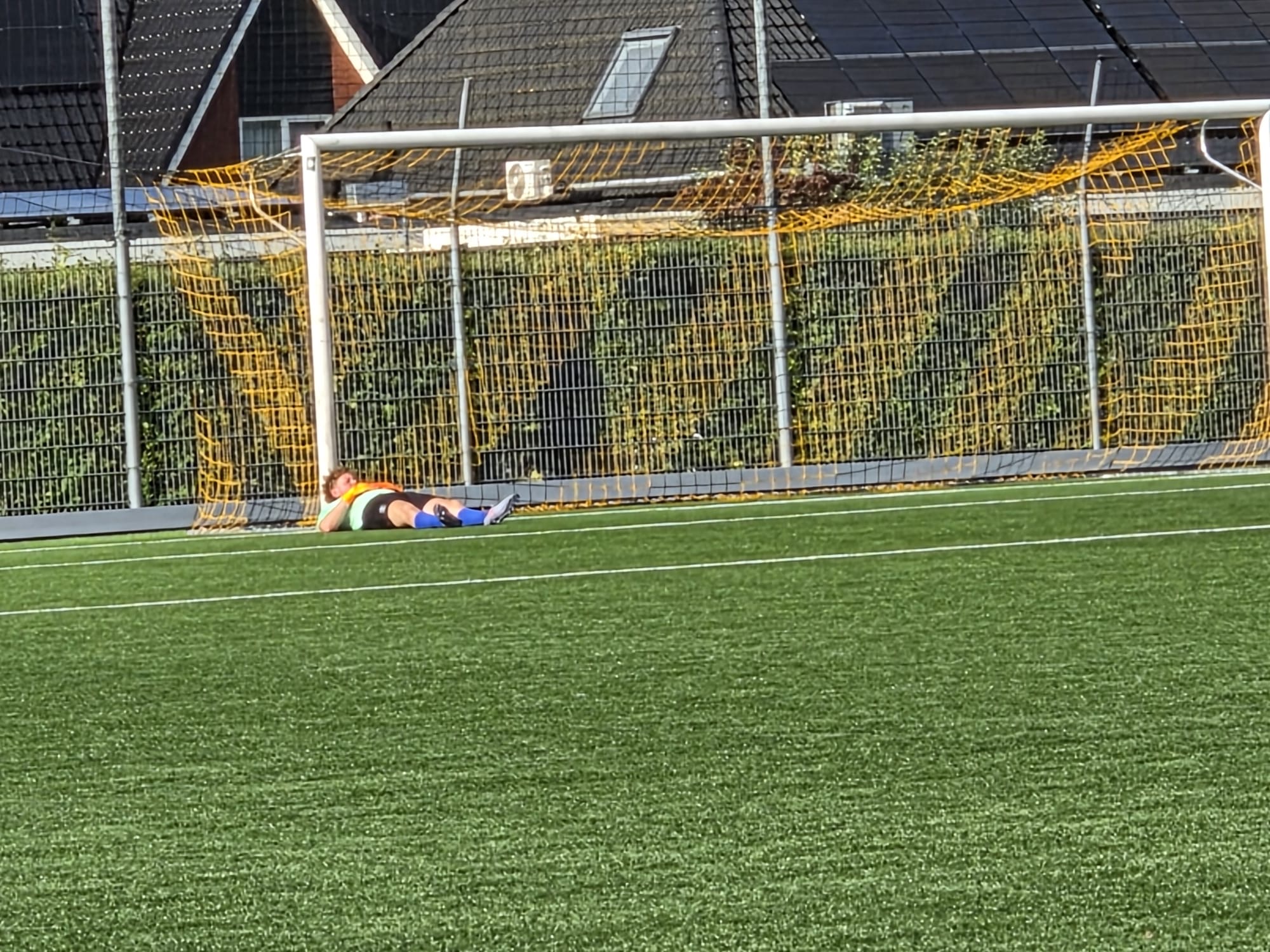 De VEV-keeper ligt verslagen na een doelpunt van Peize Zat in de 16-0 uitzege in Leek